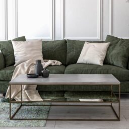 handmade mirror coffee table with corrora stone finish, placed in front of green sofa